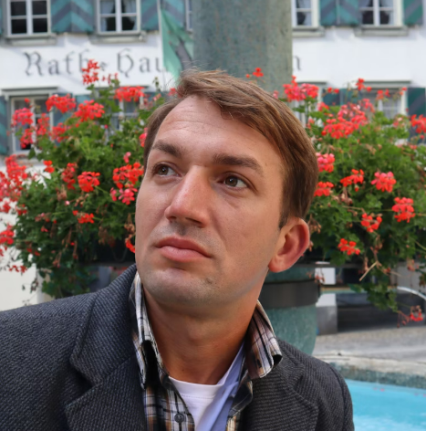 Man in a grey jacket looking up outdoors